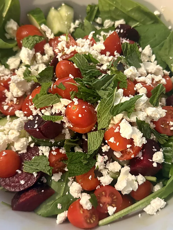 Spinach salad with beets, tomatoes, feta and mint